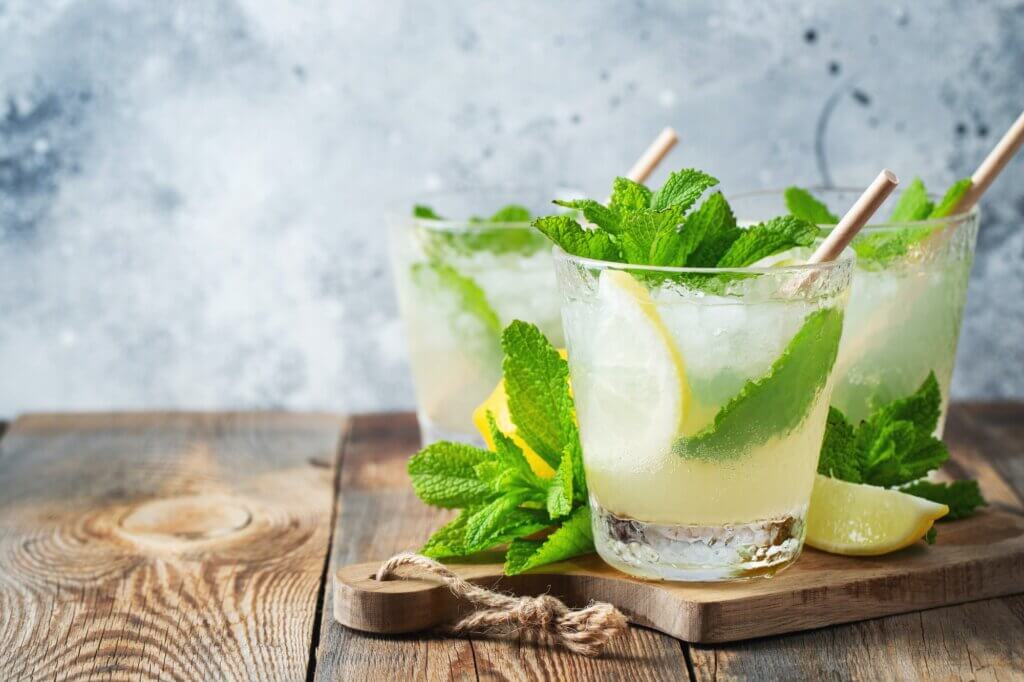 Two glass with lemonade or mojito cocktail with lemon and mint, cold refreshing drink or beverage